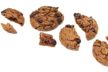 Chocolate chip cookies with some broken and crumbs isolated on white background.