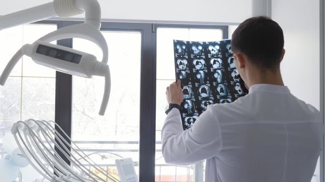 Plastic surgeon examines an x-ray image with implants