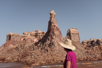Fototapeta na wymiar Unrecognized traveler looking at a desert canyon in danakil depression desert in Ethiopia