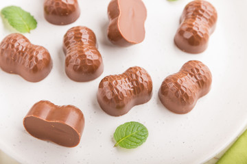 Chocolate candies with almonds on a white wooden background. side view, selective focus