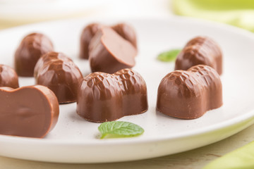 Chocolate candies with almonds on a white wooden background. side view, selective focus