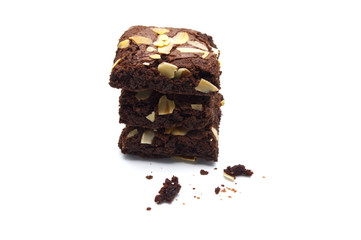 Pile of chocolate brownies with sliced almond nuts toppings and crumbs  isolated on white...