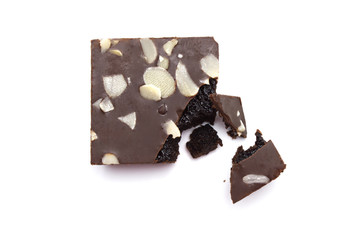 Chocolate brownie with sliced almond nuts toppings broken and crumbs isolated on white background.