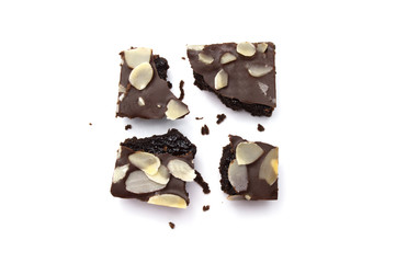 Chocolate brownie with sliced almond nuts toppings broken and crumbs isolated on white background.