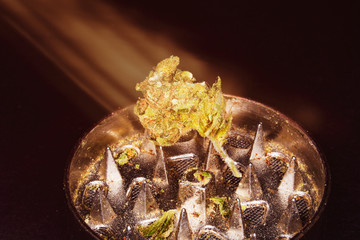 Metal grinder with marijuana, isolated on a black 