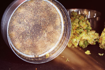 Metal grinder with marijuana, isolated on a black 