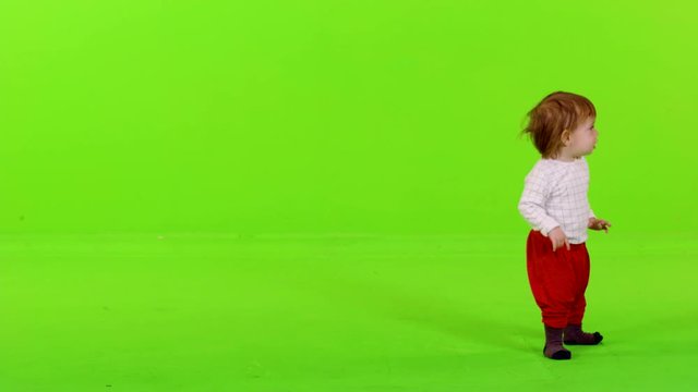 Cute little toddler running from side to side, happy, full shot over green screen. 2 takes.