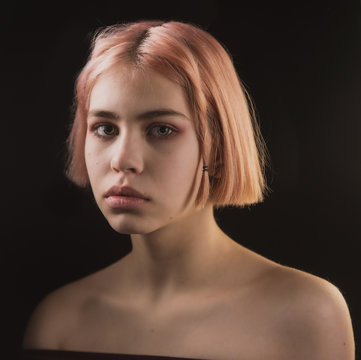 Fototapeta impulsive girl with light hair on a dark background, portrait of a girl with large facial features