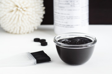 DIY activated charcoal peel off mask in the small glass bowl. Homemade beauty treatment. Copy space.