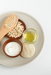 Fresh greek yogurt, oatmeal, olive oil, wooden hairbrush and body brush. Natural skin care and zero waste concept. Top view, copy space