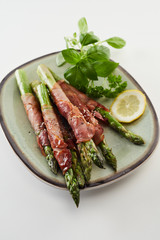 Plate of fresh green asparagus with prosciutto