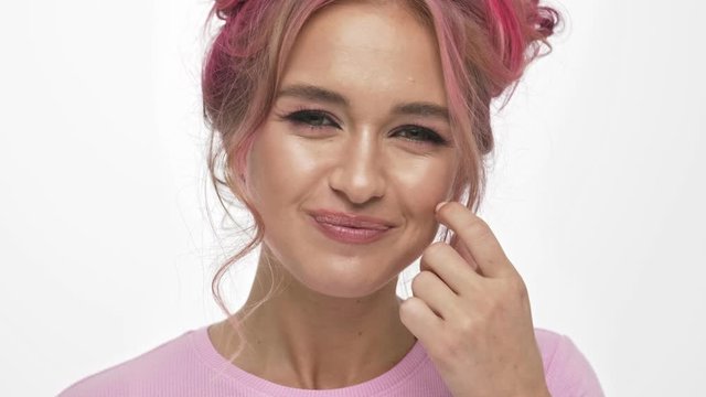 A close-up view of nice young woman inflates a gum white background