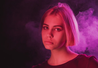 portrait of an impulsive girl with a Bob haircut in neon red and purple light