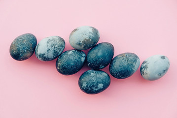 Natural dyed blue colored eggs on pastel pink background.