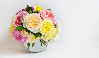 Bouquet of flowers  on white background. Roses on glass round vase, celebration concept