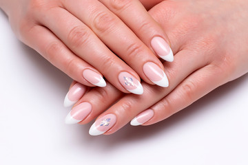 Wedding manicure. French classic manicure on long sharp nails with crystals close up on a white background