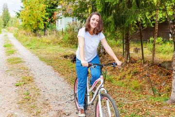 Young woman riding bicycle in summer city park outdoors. Active people. Hipster girl relax and rider bike. Cycling to work at summer day. Bicycle and ecology lifestyle concept.