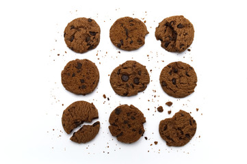 Set of chocolate chips cookies. Some broken and crumbs on white background in top view.