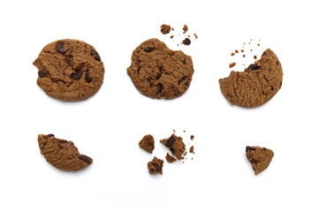 Chocolate chip cookies with some broken and crumbs on white background.