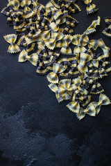 pasta farfalle cuttlefish ink (healthy eating, black multi-colored) menu concept. food background. top view. copy space