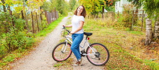 Young woman riding bicycle in summer city park outdoors. Active people. Hipster girl relax and...
