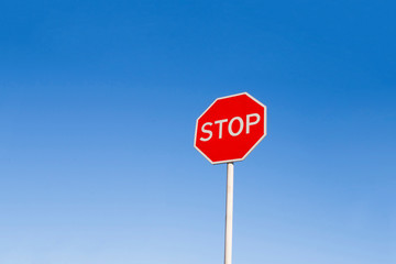 Stop sign against a blue sky. Warning, prohibiting sign.