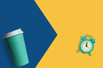 Simply flat lay design blue paper coffee cup and alarm clock isolated on blue pastel colorful background