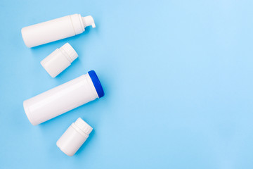 Set of white cosmetic products on a soft blue background. A number of containers for cosmetics. Female body care.