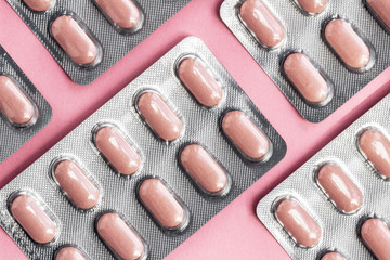 White blister pack of tablets pill statins for light resistance packaging on pink background. Pink...