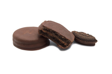 Chocolate sandwich cookies filled and coated with chocolate cream isolated on white background.