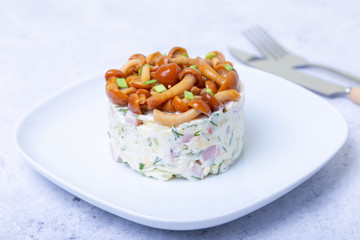 Salad with mushrooms (honey fungus), ham, potatoes, cheese and mayonnaise. Traditional Russian...