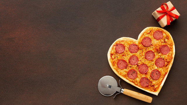 Valentine's day arrangement with heart shaped pizza and copy space