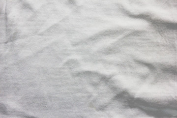 Fototapeta na wymiar Crumpled white cloth texture, used fabric sheet background. Cotton material surface, grunge light grey clothing pattern. Wrinkle on elegant shirt for men and women, blanket or sheet, close up
