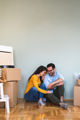 Fototapeta na wymiar We've got big plans for our new home stock photo. Portrait of a happy young couple sitting on their living room floor on moving day stock photo