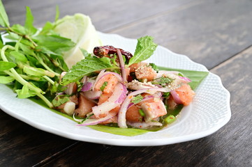 Spicy salmon or Spicy salmon salad  ( Larb Salmon). Thai style spicy and delicious. Served with mixed fresh vegetables, and many herb. 