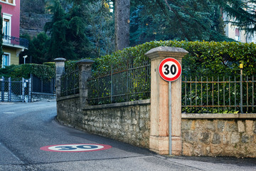 "Speed Limit" — European road traffic sign with limit of 30 km/h on the small hilly area of european small town