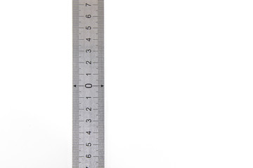 Metal ruler on a white isolated background with black numbers and scale. Vertically positioned, zero in the middle of the scale. Precise measuring tool. High quality photo.