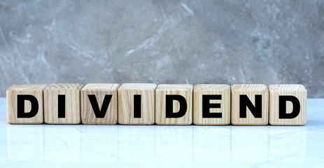 concept word dividends on cubes on a beautiful gray background