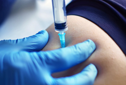 Syringe needle injects intramuscular vaccine