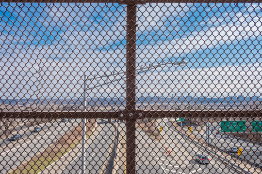 Industrial Isolated Highway Streetlamp. Looking Through Chain Link Fence Over Highway. 