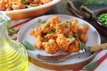 Vegetarian cuisine: spicy roasted cauliflower in tomato sauce and  with green pea