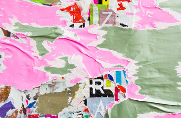 Pink and grey torn and peeling paper posters and placards layers on dirty billboard with rough...