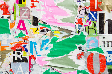 Old dirty torn and peeling paper posters and placards layers on urban wall billboard with rough...