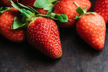 Ripe and juicy strawberry on the dark rustic background. Selective focus. Shallow depth of field.