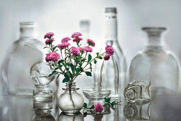 still life with glass bottles and flowers