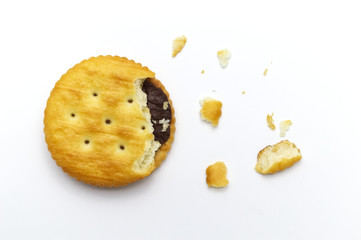 Sandwich cookies filled with chocolate cream flavored. Some broken and crumbs of crunchy delicious sweet meal and useful cookie on white background.