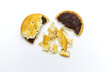 Biscuits some broken or crack and crumbs of sandwich cracker chocolate cream flavoured. Crunchy delicious sweet meal and useful cookies. On white background.