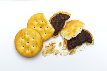 Biscuits some broken or crack and crumbs of sandwich cracker chocolate cream flavoured. Crunchy delicious sweet meal and useful cookies. On white background.