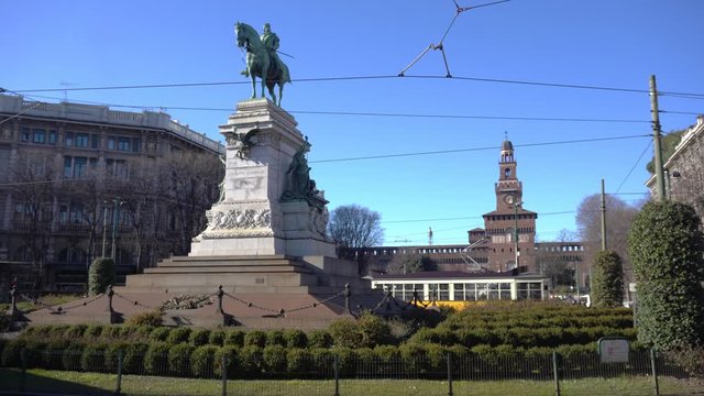 Italy , Milan  February 2020 - Cairoli square in downtown of the city - the famous statue of Giuseppe Garibaldi on a horse and sforza Castle ( Castello Sforzesco ) behinds - Old yellow tram Streetcar 