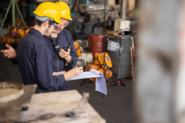 Group of industrial factory maintenance engineers inspect relay protection system using walkie...